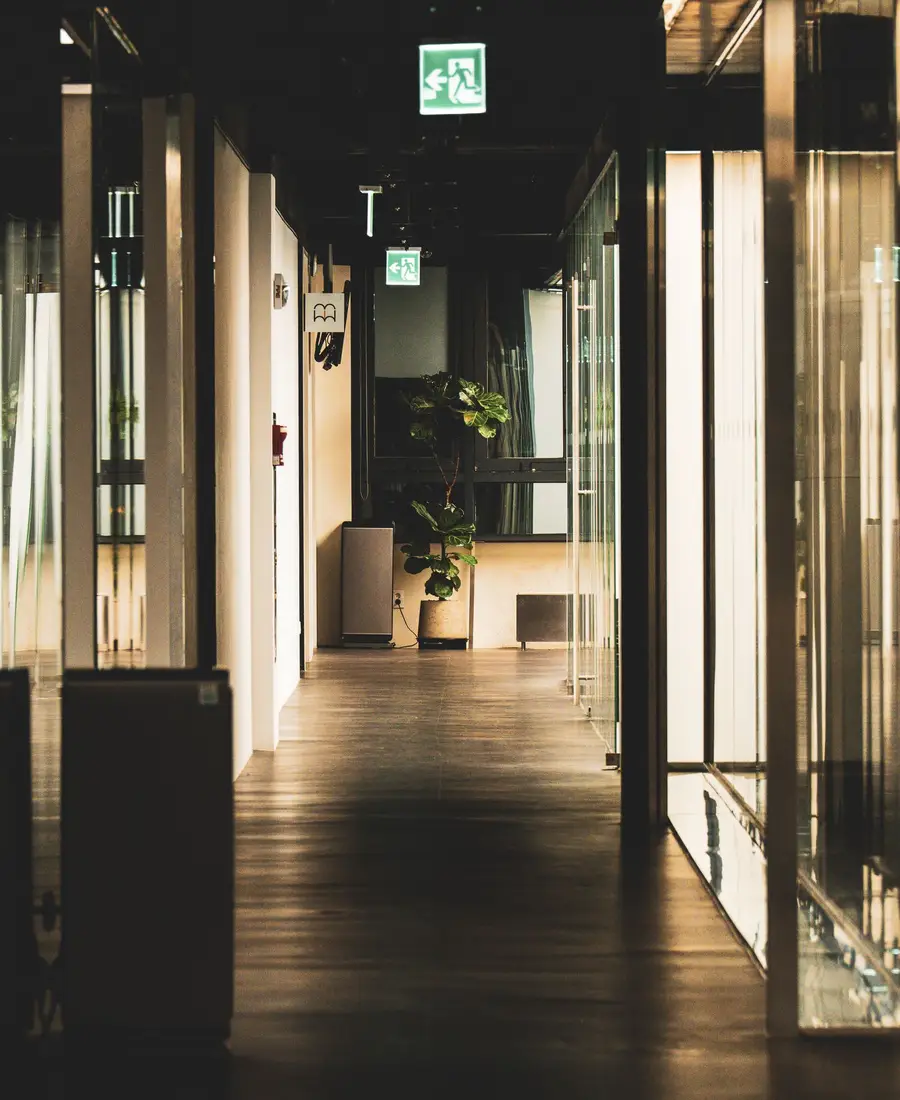 A quiet, empty office corridor with warm light and no visible signage